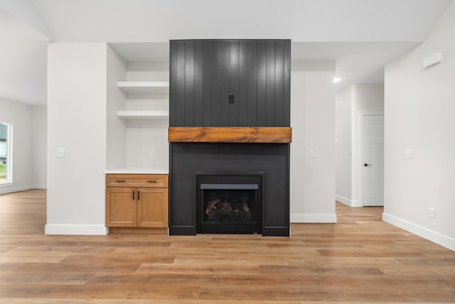 unfurnished living room with a fireplace and light wood-type flooring