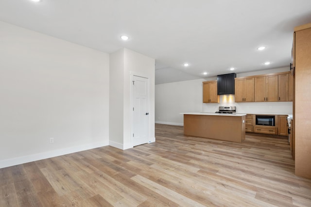 kitchen featuring light wood-type flooring, stainless steel range, a kitchen island, and black microwave