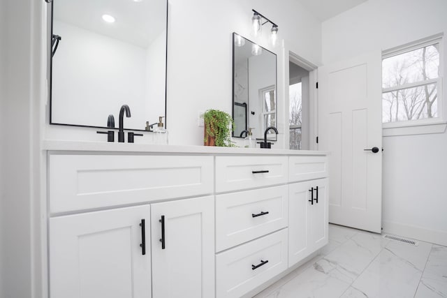 full bath featuring double vanity, marble finish floor, baseboards, visible vents, and recessed lighting