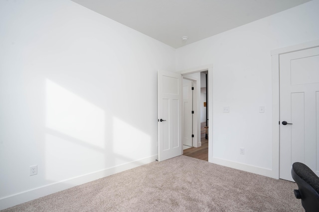 unfurnished bedroom featuring baseboards and carpet