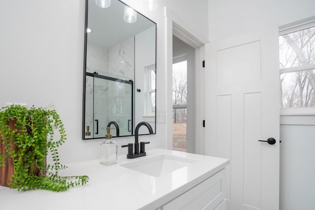 full bathroom featuring a marble finish shower and vanity