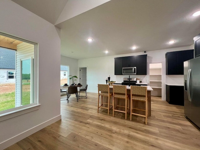 dining area with vaulted ceiling and light hardwood / wood-style flooring