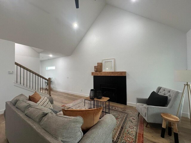 living room with light wood-type flooring and high vaulted ceiling