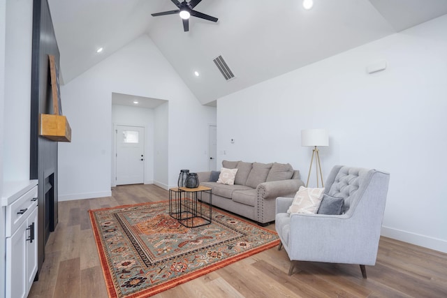 living room featuring ceiling fan, high vaulted ceiling, and light hardwood / wood-style floors