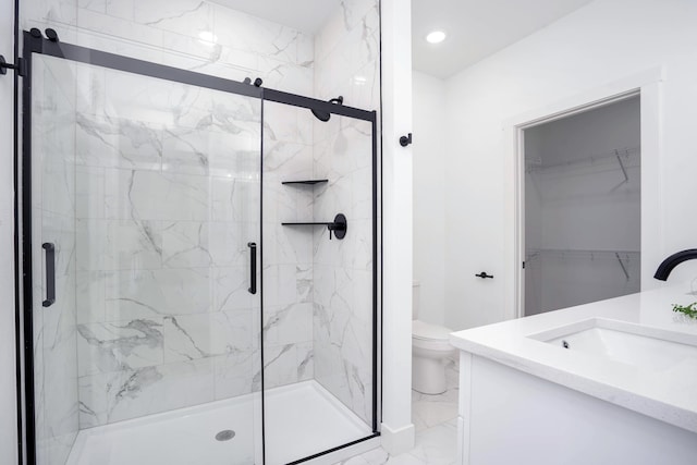 bathroom featuring vanity, an enclosed shower, and toilet