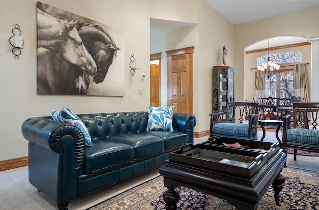 living room with ornate columns, lofted ceiling, carpet, and a notable chandelier