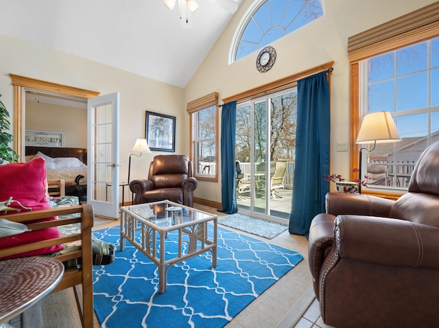 tiled living room featuring high vaulted ceiling, french doors, and ceiling fan