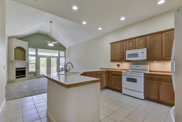 kitchen with lofted ceiling, sink, white appliances, light tile patterned floors, and kitchen peninsula