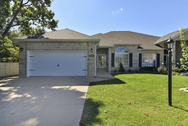 ranch-style home featuring a garage and a front yard