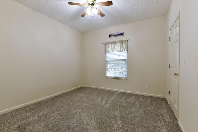 carpeted spare room featuring ceiling fan and a textured ceiling