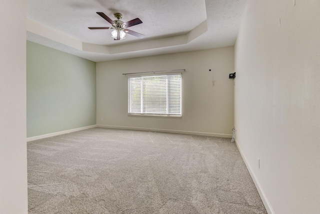 unfurnished room with light carpet, a raised ceiling, and ceiling fan