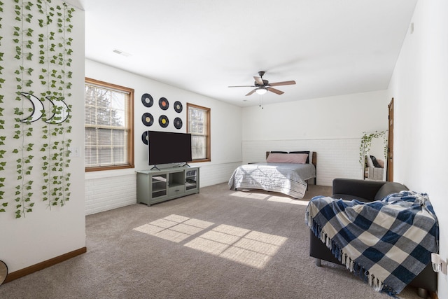 bedroom featuring ceiling fan, brick wall, and carpet flooring