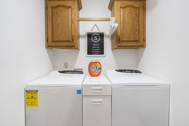 clothes washing area featuring cabinets and washing machine and clothes dryer