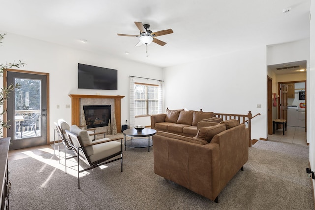 carpeted living room featuring a tile fireplace and ceiling fan