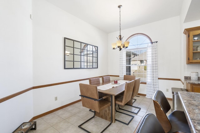 tiled dining room featuring a chandelier