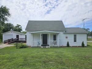 back of house featuring a yard and covered porch