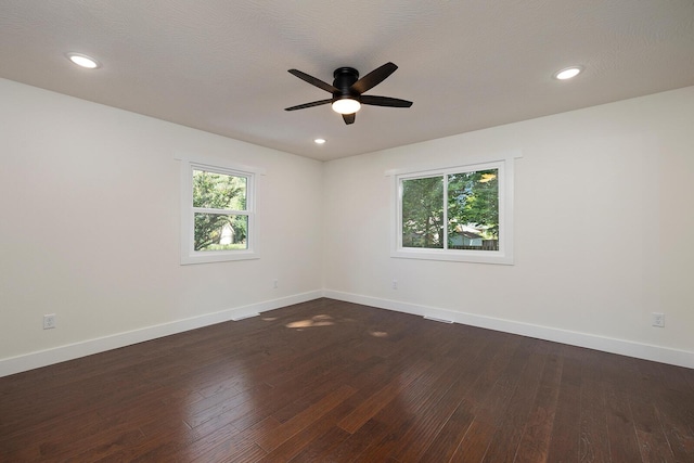 empty room featuring ceiling fan, dark hardwood / wood-style floors, and a textured ceiling