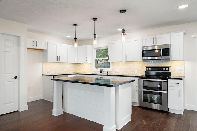 kitchen featuring pendant lighting, sink, white cabinets, a center island, and stainless steel appliances