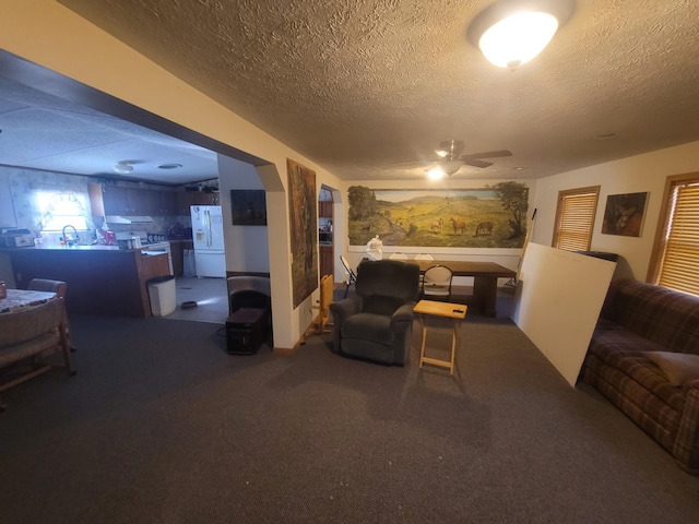 living room with ceiling fan and a textured ceiling