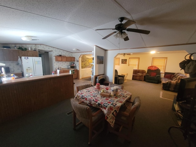 dining area with vaulted ceiling, ceiling fan, and carpet