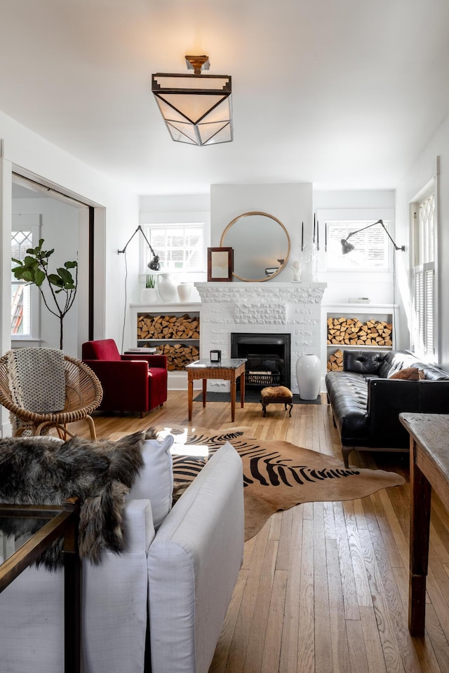 living room with hardwood / wood-style floors, plenty of natural light, and a tile fireplace