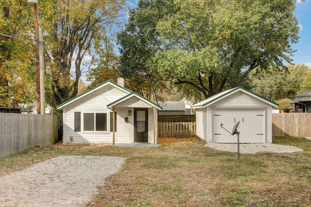 view of front of property featuring a garage, an outbuilding, and a front yard