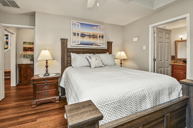 bedroom featuring ceiling fan, dark hardwood / wood-style floors, and ensuite bath