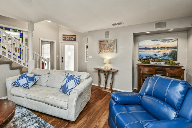 living room featuring decorative columns and dark hardwood / wood-style flooring