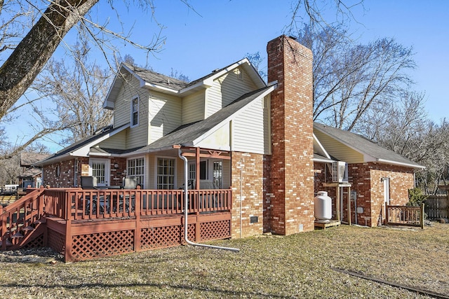 rear view of property with a lawn and a deck