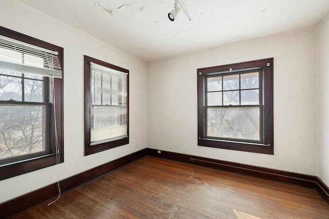 unfurnished room with plenty of natural light and dark hardwood / wood-style floors