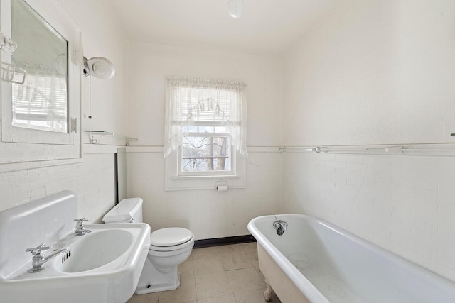 bathroom featuring toilet, sink, and a tub