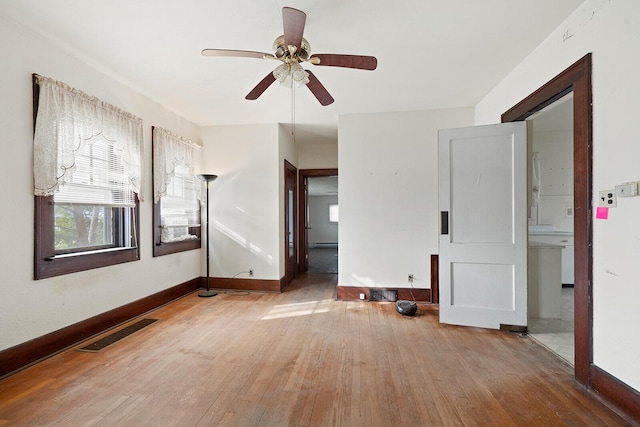 unfurnished room with ceiling fan, wood-type flooring, and a baseboard heating unit