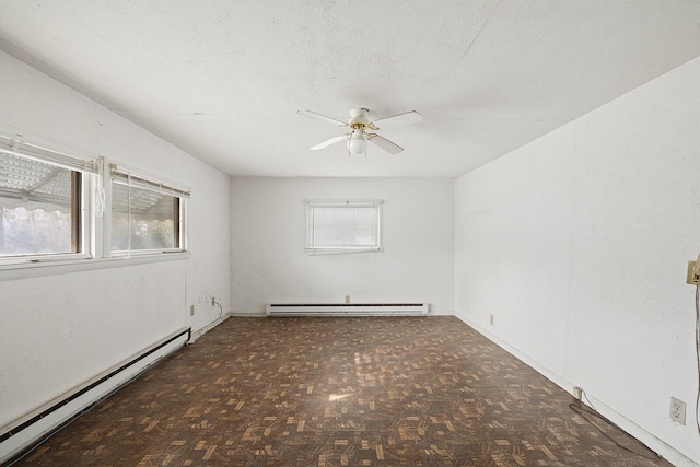 spare room with a wealth of natural light, a textured ceiling, and baseboard heating