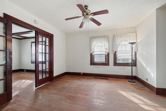 spare room with hardwood / wood-style floors, french doors, and ceiling fan