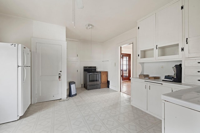 kitchen with white cabinetry, electric range, washer / dryer, and white refrigerator