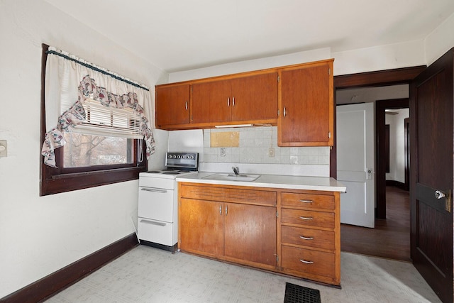 kitchen featuring sink, backsplash, and white range with electric cooktop