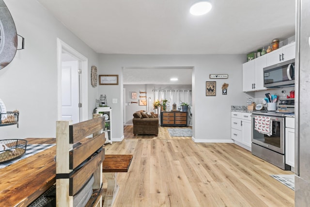 kitchen with white cabinetry, light hardwood / wood-style floors, and appliances with stainless steel finishes