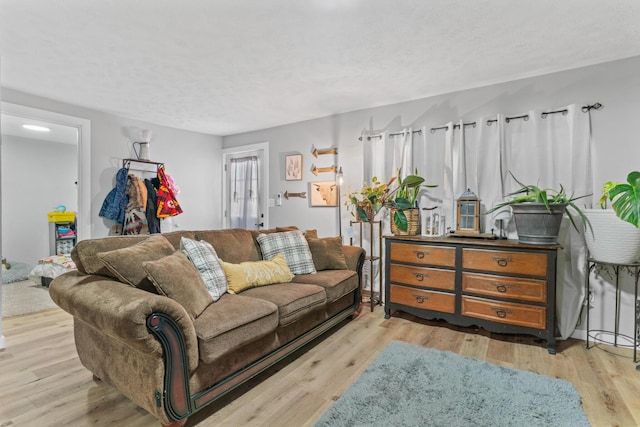 living room featuring a textured ceiling and light hardwood / wood-style floors