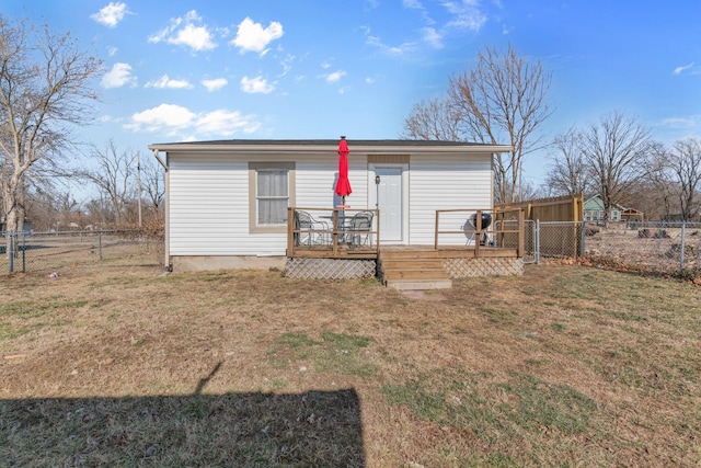 rear view of property featuring a deck and a lawn