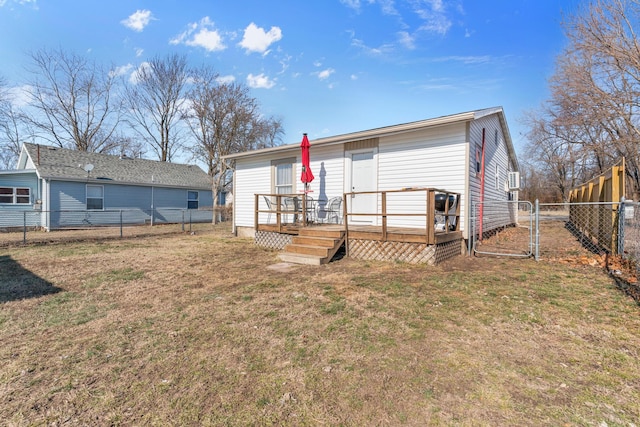 rear view of property featuring a wooden deck and a yard