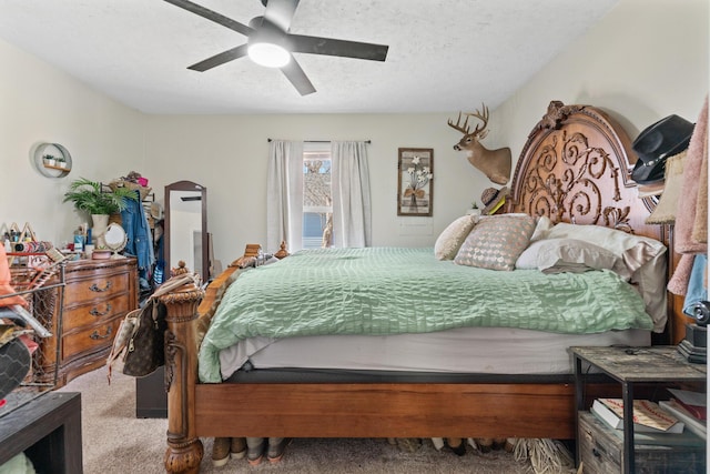 bedroom with ceiling fan, carpet, and a textured ceiling