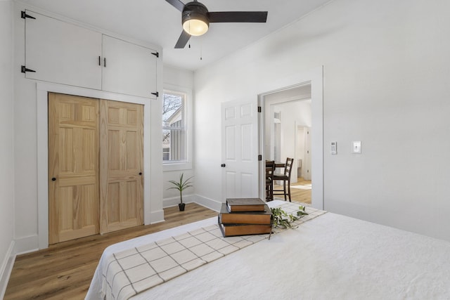 bedroom featuring wood-type flooring, ceiling fan, and a closet