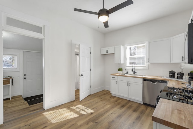 kitchen featuring white cabinetry, butcher block countertops, sink, and dishwasher