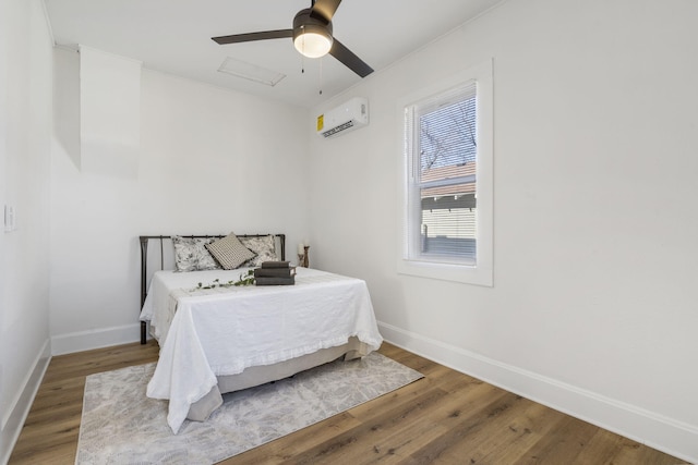 bedroom with ceiling fan, a wall mounted air conditioner, and hardwood / wood-style floors