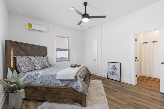 bedroom with dark wood-type flooring, ceiling fan, and a wall mounted air conditioner