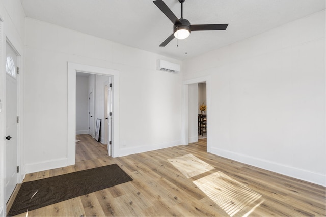 empty room with ceiling fan, light hardwood / wood-style flooring, and an AC wall unit