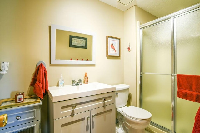 full bathroom with vanity, a shower stall, and toilet