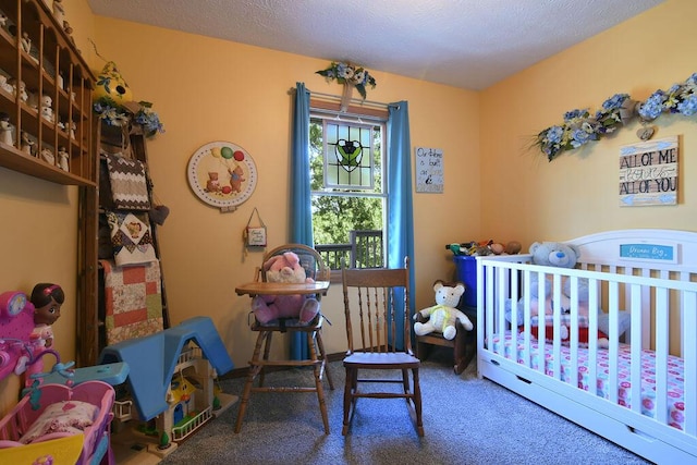 carpeted bedroom with a crib and a textured ceiling