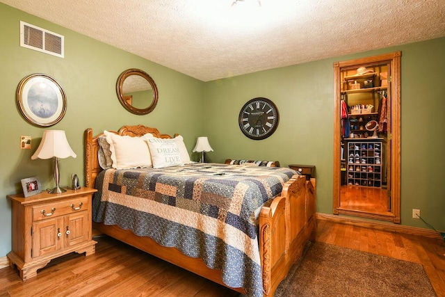 bedroom featuring hardwood / wood-style flooring and a textured ceiling