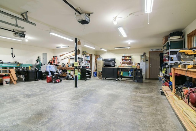 garage with a workshop area and a garage door opener